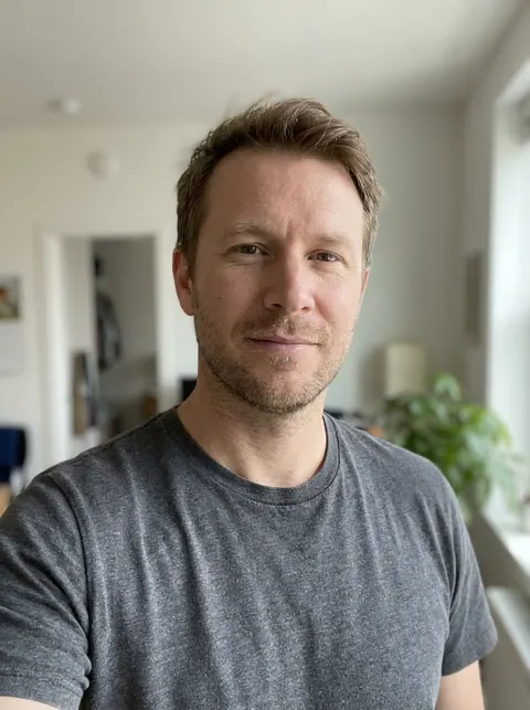Input photo: a man with light-brown hair and stubble